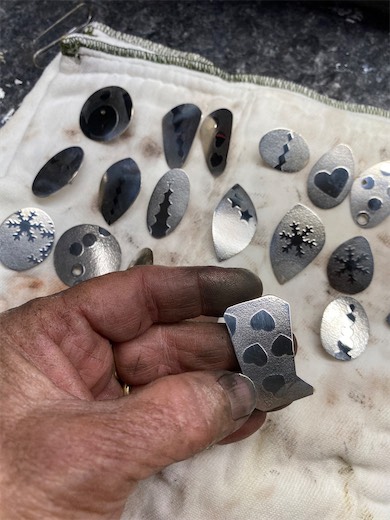 Hands arranging small gemstone settings
