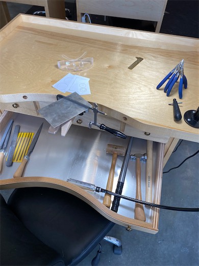 Jewelry-making tools laid out on a workbench