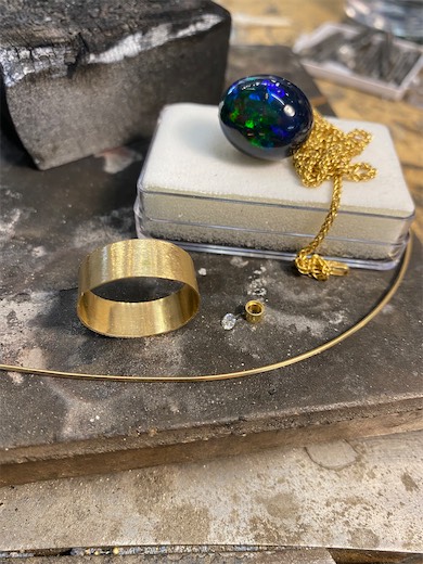 Gemstone jewelry project and ring at a workbench