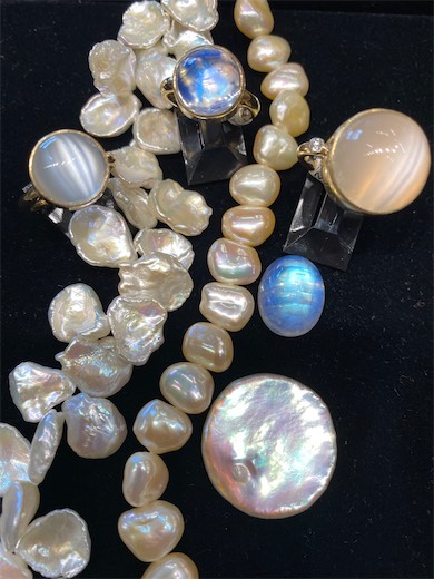 Pearl strands and loose pearls with iridescent surfaces