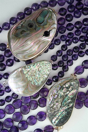Patterned pendants displayed on purple beads